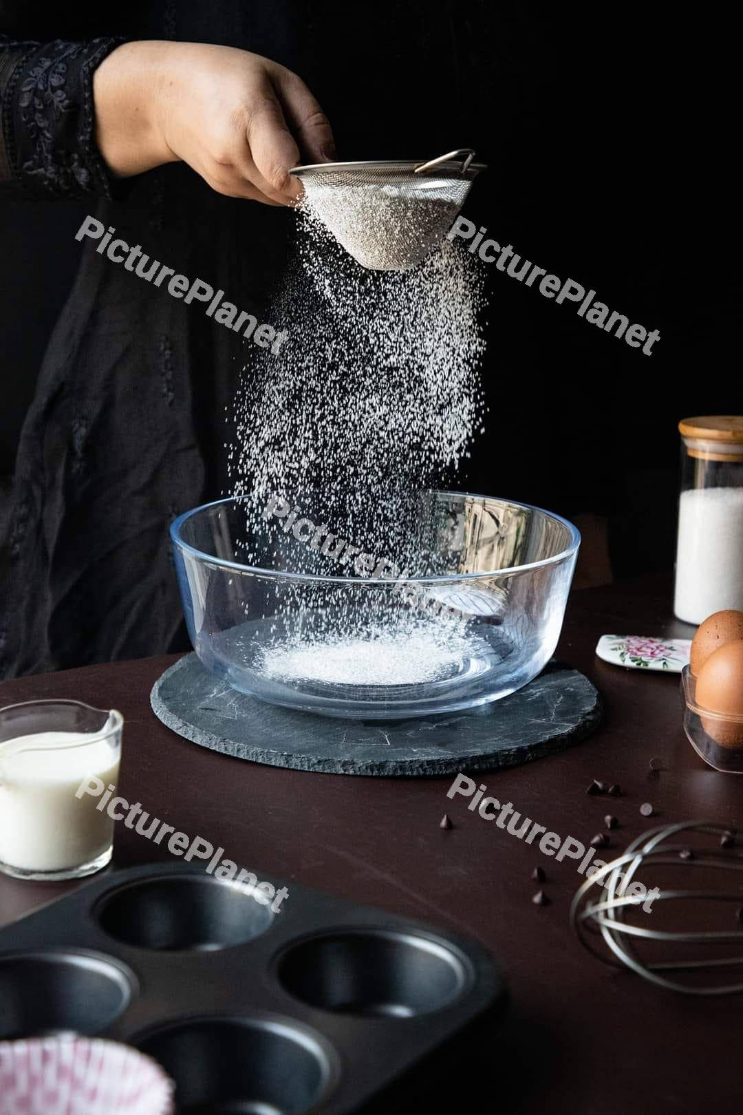 Hand pouring sugar into a bowl